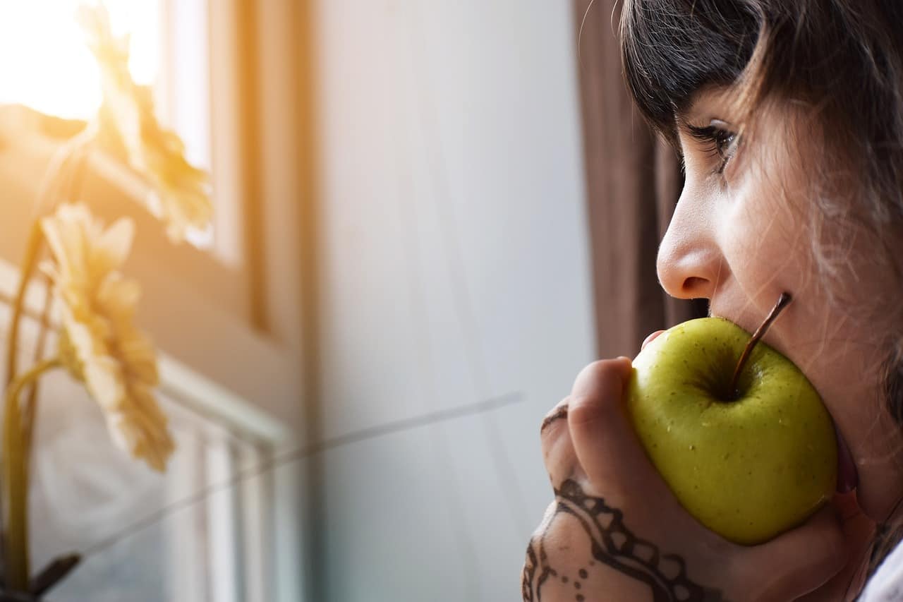 niña comiendo una manzana